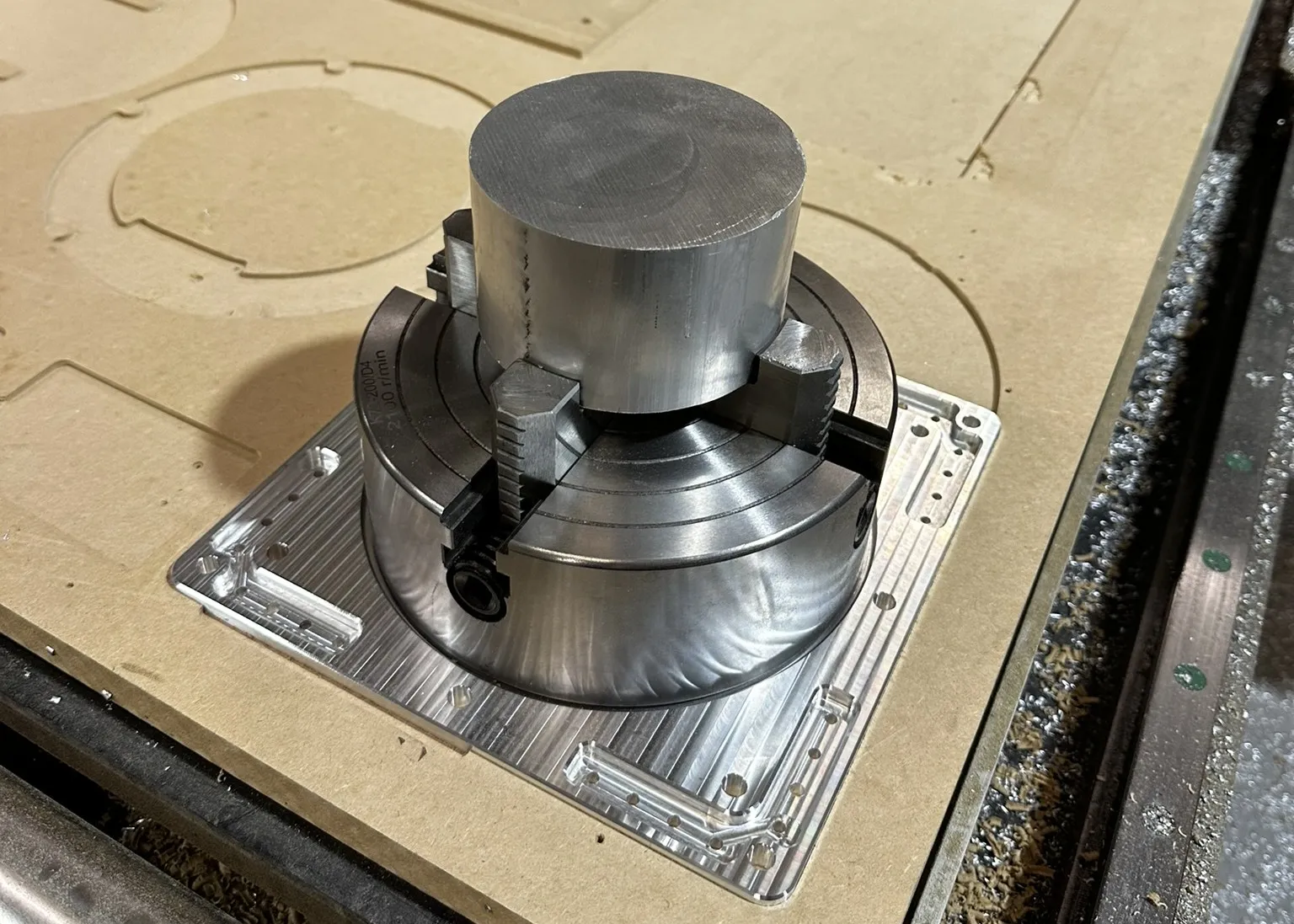 FRC shooter wheel rim mounted in a four jaw chuck fixture plate