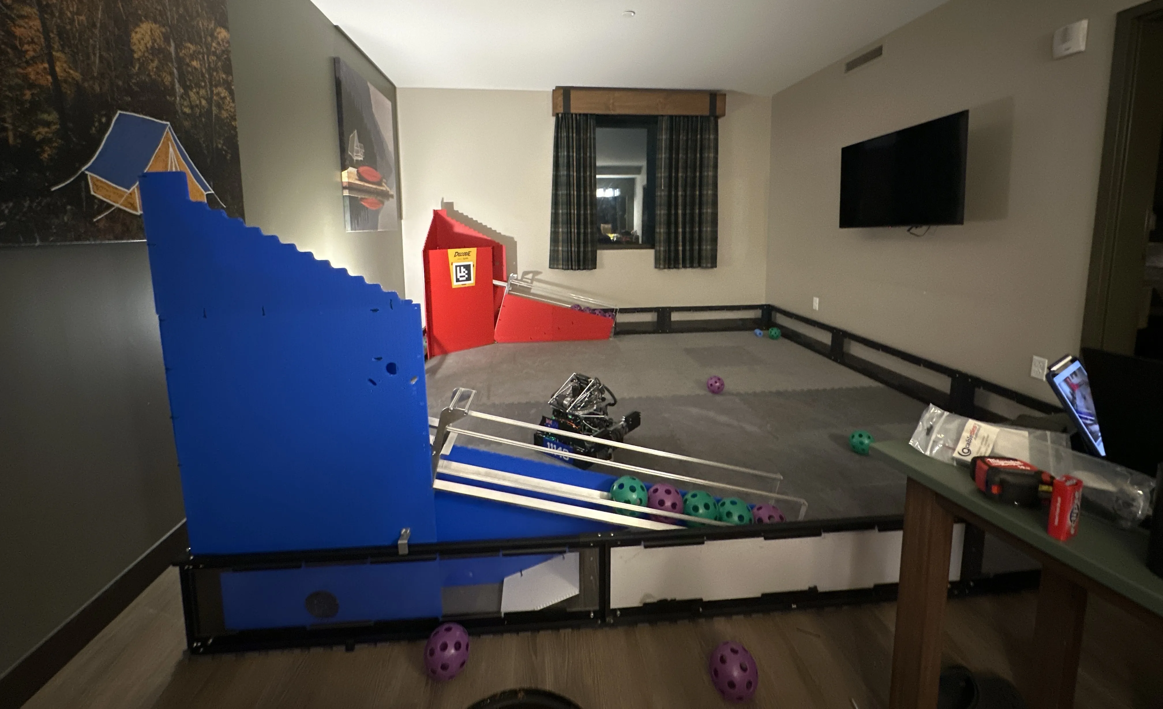 Hotel room converted into a partial FTC field with the robot, game pieces and goal