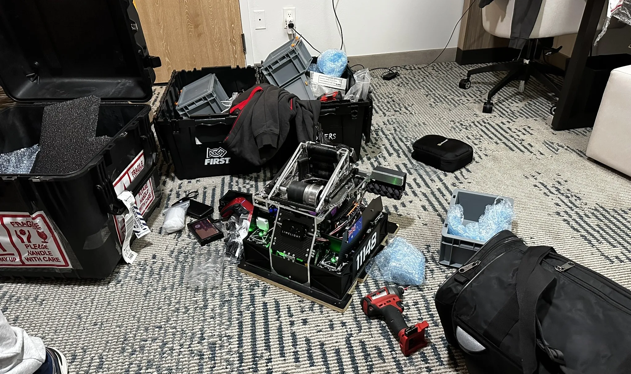 Competition robot unpacked beside its travel cases in Dallas