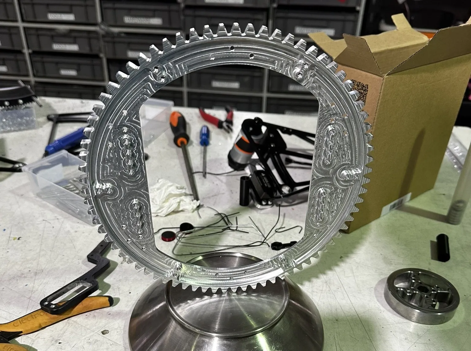 Machined aluminium turret gear resting on a scale reading 183 grams